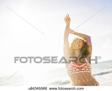 Stock Photograph - Young woman smiling on beach. Fotosearch