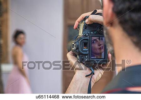 Behind the scenes of an urban fashion shoot with female model and male photographer View Large Photo Image Stock Photo - Behind the scenes of an urban fashion shoot with female model and male photographer. Fotosearch