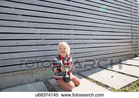 Boy holding a trophy View Large Photo Image Stock Photography - Boy holding a trophy. Fotosearch