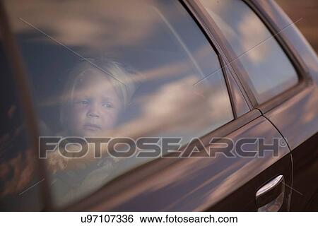 Boy looking through car window View Large Photo Image Stock Photograph - Boy looking through car window. Fotosearch