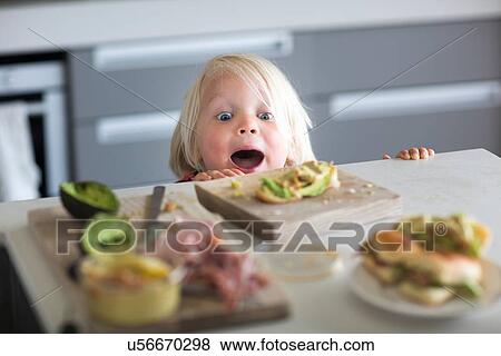 Stock Photo - Boy peeking over kitchen counter. Fotosearch