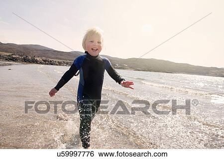 Stock Photograph - Boy running on beach, Loch Eishort, Isle of Skye, Hebrides, Scotland. Fotosearch