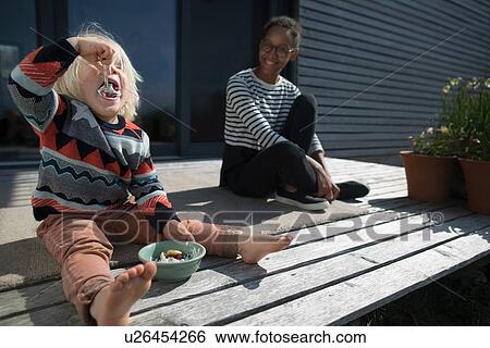 Boy sitting on wooden decking eating from bowl View Large Photo Image Stock Photograph - Boy sitting on wooden decking eating from bowl. Fotosearch