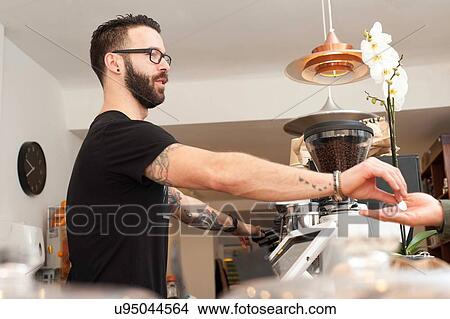 Cafe waiter handing coins to customer from behind counter View Large Photo Image Picture - Cafe waiter handing coins to customer from behind counter. Fotosearch