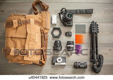 Stock Photography - Camera equipment and camera bag arranged on table, overhead view. Fotosearch