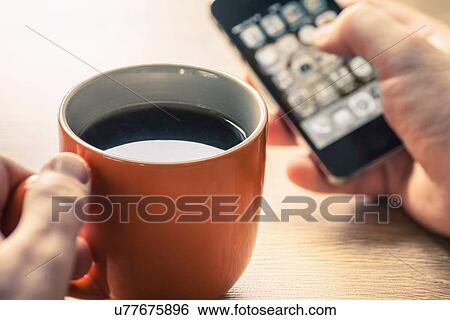Stock Photograph - Close up of mans hands using smartphone touchscreen. Fotosearch