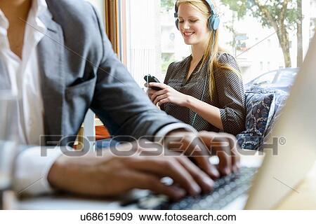 Stock Photo - Close up of young man typing on laptop in cafe. Fotosearch