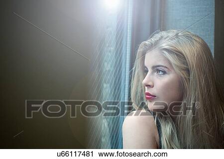 Close up portrait of beautiful blond young woman looking through hotel window View Large Photo Image Stock Image - Close up portrait of beautiful blond young woman looking through hotel window. Fotosearch