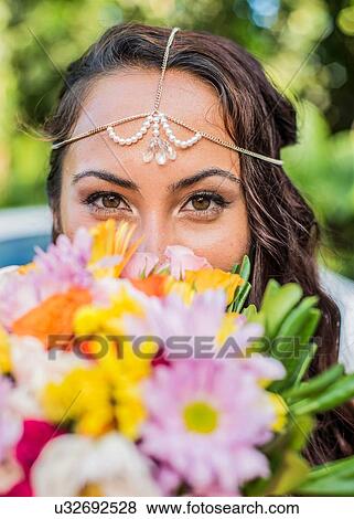 Stock Photo - Close up portrait of bride behind colorful boquet at Hawaiian wedding, Kaaawa, Oahu, Hawaii, USA. Fotosearch