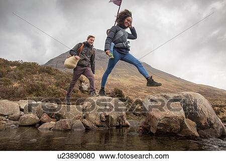 Couple crossing river, Fairy Pools, near Glenbrittle, Isle of Skye, Hebrides, Scotland View Large Photo Image Stock Image - Couple crossing river, Fairy Pools, near Glenbrittle, Isle of Skye, Hebrides, Scotland. Fotosearch
