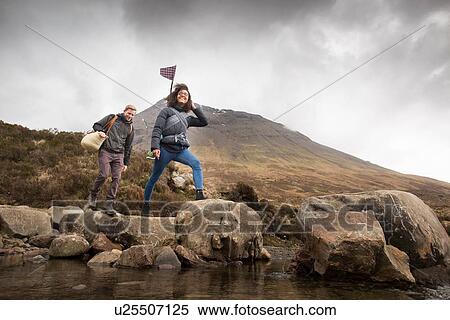 Couple crossing river, Fairy Pools, near Glenbrittle, Isle of Skye, Hebrides, Scotland View Large Photo Image Stock Photography - Couple crossing river, Fairy Pools, near Glenbrittle, Isle of Skye, Hebrides, Scotland. Fotosearch
