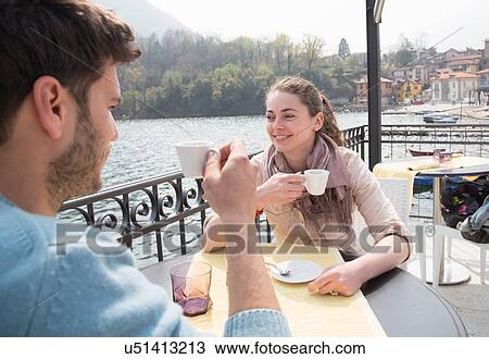 Stock Image - Couple drinking espresso at lakeside restaurant, Lake Mergozzo, Verbania, Piemonte, Italy. Fotosearch