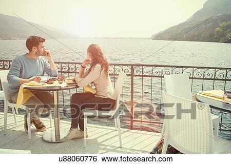 Couple looking out from lakeside restaurant, Lake Mergozzo, Verbania, Piemonte, Italy View Large Photo Image Stock Photograph - Couple looking out from lakeside restaurant, Lake Mergozzo, Verbania, Piemonte, Italy. Fotosearch