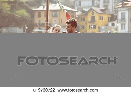 Couple sitting on pier sharing ice cream cone at lake Mergozzo, Verbania, Piemonte, Italy View Large Photo Image Stock Image - Couple sitting on pier sharing ice cream cone at lake Mergozzo, Verbania, Piemonte, Italy. Fotosearch