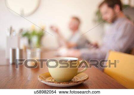 Picture - Cup on table and people in background in a cafe. Fotosearch