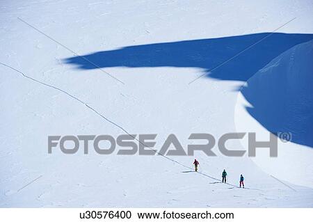 Distant view of three skiers on track, Mont Blanc massif, Graian Alps, France View Large Photo Image Stock Image - Distant view of three skiers on track, Mont Blanc massif, Graian Alps, France. Fotosearch