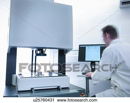 Stock Image - Engineer measuring parts in quality control room. Fotosearch