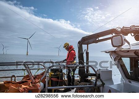 Stock Photograph - Engineer on deck of service boat at offshore windfarm. Fotosearch