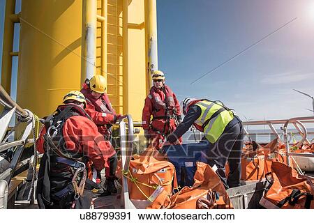 Engineers on boat preparing to climb wind turbine on offshore windfarm View Large Photo Image Stock Image - Engineers on boat preparing to climb wind turbine on offshore windfarm. Fotosearch