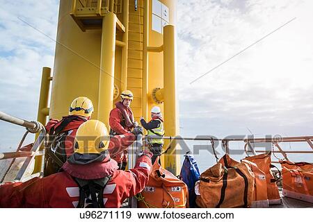 Engineers preparing to climb wind turbine on offshore windfarm View Large Photo Image Stock Photo - Engineers preparing to climb wind turbine on offshore windfarm. Fotosearch