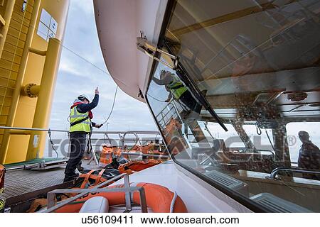 Engineers winching parts up to wind turbine on offshore windfarm View Large Photo Image Stock Image - Engineers winching parts up to wind turbine on offshore windfarm. Fotosearch