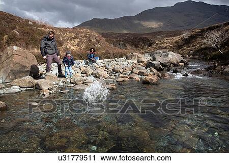 Family throwing stones in pond, Fairy Pools, Isle of Skye, Hebrides, Scotland View Large Photo Image Stock Image - Family throwing stones in pond, Fairy Pools, Isle of Skye, Hebrides, Scotland. Fotosearch