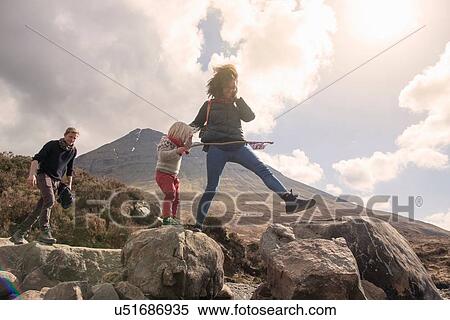 Stock Photography - Family walking over boulders, Fair Pools, Isle of Skye, Hebrides, Scotland. Fotosearch