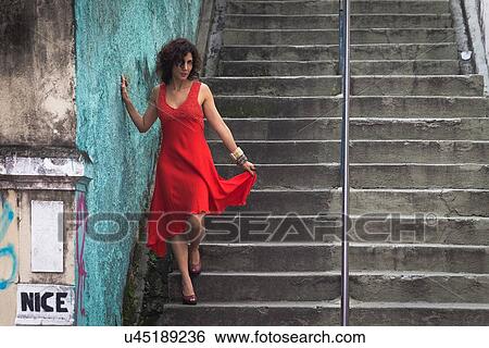Fashion model wearing red dress walking down steps View Large Photo Image Stock Photograph - Fashion model wearing red dress walking down steps. Fotosearch
