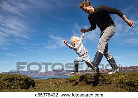 Father and son holding hands running, Isle of Skye, Hebrides, Scotland View Large Photo Image Stock Image - Father and son holding hands running, Isle of Skye, Hebrides, Scotland. Fotosearch