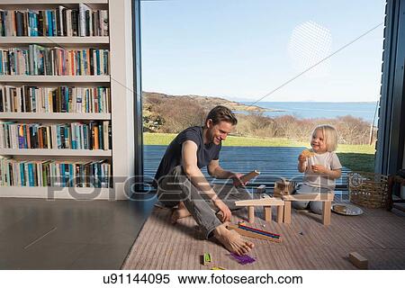 Father and son playing with wooden blocks at home View Large Photo Image Stock Photography - Father and son playing with wooden blocks at home. Fotosearch