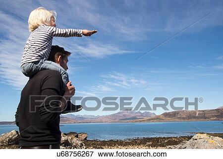Stock Photo - Father carrying son on shoulders, Loch Eishort, Isle of Skye, Hebrides, Scotland. Fotosearch