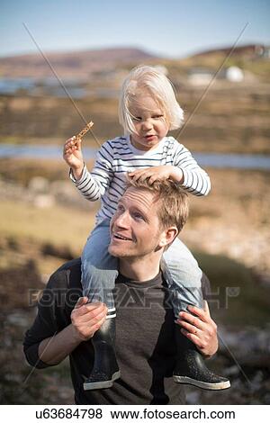 Stock Photo - Father carrying son on shoulders. Fotosearch