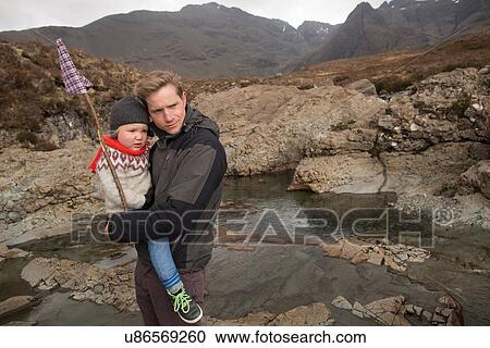 Father holding son, Fairy Pools, Isle of Skye, Hebrides, Scotland View Large Photo Image Stock Image - Father holding son, Fairy Pools, Isle of Skye, Hebrides, Scotland. Fotosearch