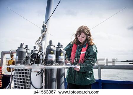Female scientist making notes with sea water sampling experiment on research ship View Large Photo Image Stock Photo - Female scientist making notes with sea water sampling experiment on research ship. Fotosearch