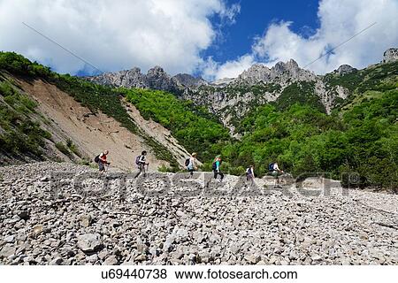 Stock Photo - Five mature hikers hiking in valley, Grigna, Lecco, Lombardy, Italy. Fotosearch