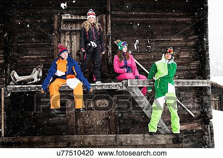 Four friends outside chalet wearing skiwear View Large Photo Image Stock Image - Four friends outside chalet wearing skiwear. Fotosearch
