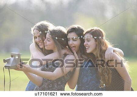 Four teenage girls in park taking instant camera selfie View Large Photo Image Stock Image - Four teenage girls in park taking instant camera selfie. Fotosearch