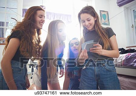 Four teenage girls looking at instant photographs in bedroom View Large Photo Image Stock Image - Four teenage girls looking at instant photographs in bedroom. Fotosearch