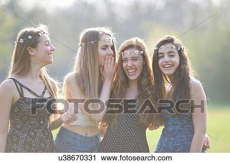 Four teenage girls wearing daisy chain headdresses giggling in park View Large Photo Image Stock Image - Four teenage girls wearing daisy chain headdresses giggling in park. Fotosearch