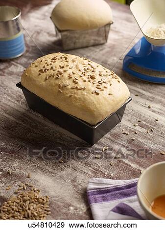 Stock Photo - Freshly baked bread in loaf tin on table. Fotosearch