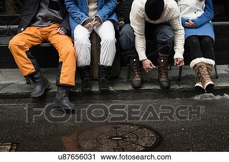 Friend sitting on bench, man tying shoelaces View Large Photo Image Stock Image - Friend sitting on bench, man tying shoelaces. Fotosearch