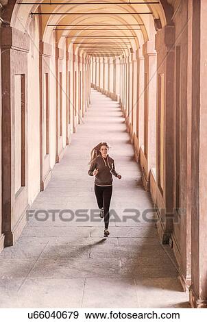 Front view of young woman wearing sports clothes jogging View Large Photo Image Stock Photo - Front view of young woman wearing sports clothes jogging. Fotosearch