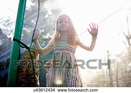 Girl in garden trampoline View Large Photo Image Picture - Girl in garden trampoline. Fotosearch