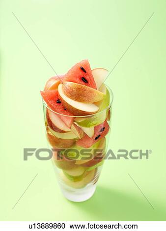 Glass full of apple and melon slices on light green background View Large Photo Image Stock Image - Glass full of apple and melon slices on light green background. Fotosearch