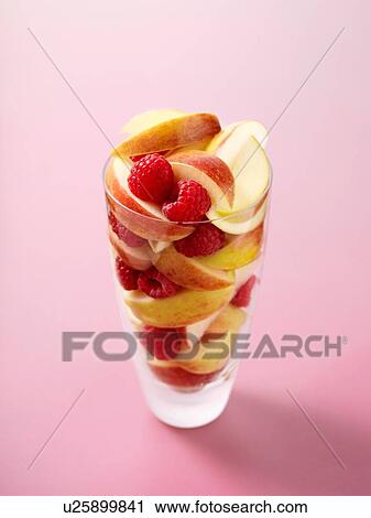 Glass full of raspberries and apple slices on pink background View Large Photo Image Stock Image - Glass full of raspberries and apple slices on pink background. Fotosearch