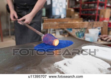 Stock Photo - Glassblower adding colour to hot glass. Fotosearch