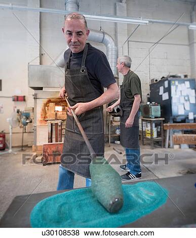 Stock Photo - Glassblower adding colour to hot glass. Fotosearch