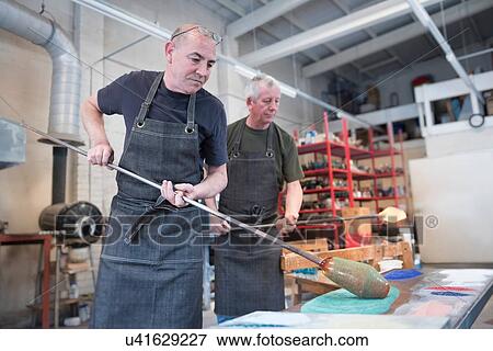 Stock Photo - Glassblower adding colour to hot glass. Fotosearch