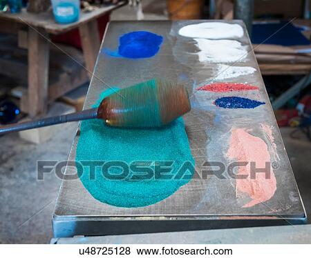 Stock Photo - Glassblower adding colour to hot glass. Fotosearch