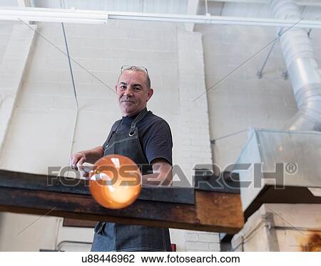 Glassblower blowing hot glass View Large Photo Image Stock Image - Glassblower blowing hot glass. Fotosearch